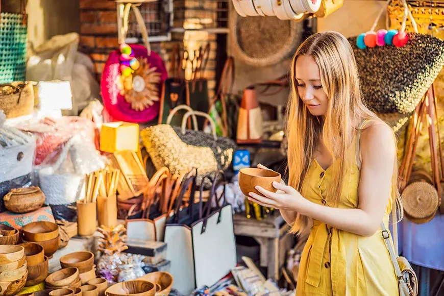 Woman traveler choose souvenirs in the market at Ubud in Bali, Indonesia